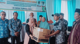 Wakil Bupati Tojo  Una-Una, Hj.Surya, S.Sos, M.Si, saat menyerahkan bantuan pembebasan lahan untuk pembangunan jaringan listrik di Desa Tombulawa, Minggu 4 Mei 2025
