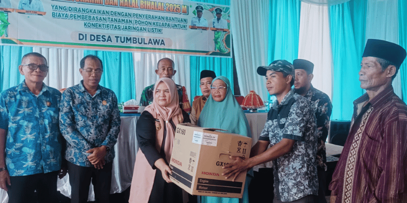 Wakil Bupati Tojo  Una-Una, Hj.Surya, S.Sos, M.Si, saat menyerahkan bantuan pembebasan lahan untuk pembangunan jaringan listrik di Desa Tombulawa, Minggu 4 Mei 2025
