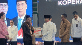 Bupati Tojo Una-Una Ilham Lawidu saat menerima Akta Notaris Koperasi Merah Putih dari Menteri Koordinator Bidang Pangan, Zulkifli Hasan, di Kota Palu, Kamis (22 Mei 2025).