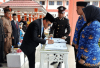 Bupati Tojo una-una Ilham Lawidu saat menandantangani berita acara penyerahan SK 51 CPNS pada peringatan Hari Lahir Pancasila ke-80, Minggu (1/6/2025).