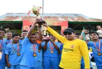 Bupati Tojo Una-una, Ilham Lawidu menyerahkan piala sepak bola kepada BMU FC; di Kecamatan Ulubongka, Jumat 25 Juli 2025