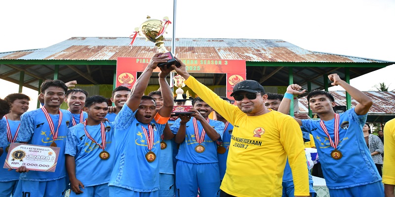Bupati Tojo Una-una, Ilham Lawidu menyerahkan piala sepak bola kepada BMU FC; di Kecamatan Ulubongka, Jumat 25 Juli 2025