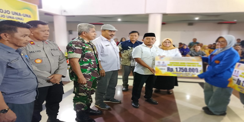 Anggota DPRD Tojo Una-Una, Sutrianto menyerahkan bantuan pendidikan kepada salah seorang Mahasiswi diruang lobi kantor bupati, Jumat (1/8)