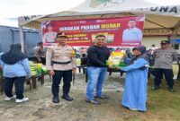 
Kajari Tojo Una-una, Dr. Rizky saat menyerahkan beras murah kepada salah satu warga masyarakat, Ahad (10/8/25).