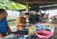 Bupati Touna, Ilham Lawidu saat menandatangi dokumen yang diajukan Plt. Kepala Dinas Perhubungan di kedai kopi milik Mas No, pada Selasa (28/10/2025)