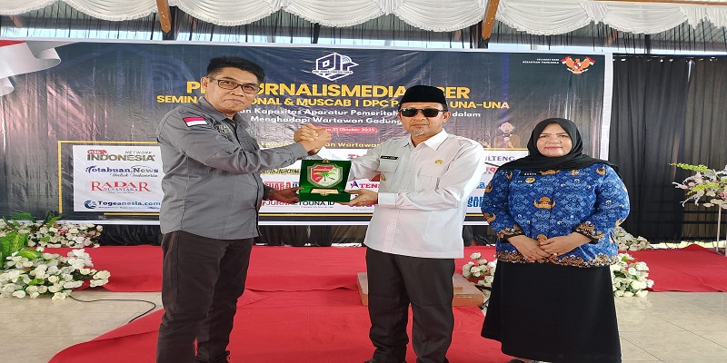 Ketua Umum Pro Jurnalismedia Siber  (PJS) Mahmud Marhaba menyerahkan cinderamata kepda Bupati Tojo Una- una Ilham Lawidu yang didampingi wakil bupati Hj Surya. (ist)