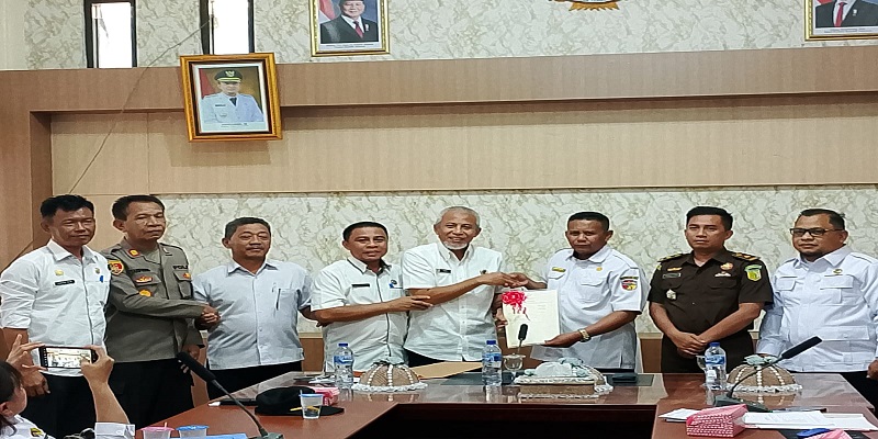 Kepala Kantor Pertanahan Touna, Said Salim Niode saat menyerahkan Sertifikat Tanah SR kepada Pemda Touna yang diterima oleh Asisten II Setda Touna, Mohammad M. Ali pada Rabu (29/10/2025)