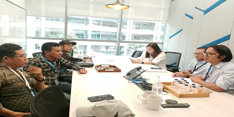 Kadis Pariwisata Touna, Asrin W. Soga mengunakan kemeja lengan panjang kotak-kotak saat bersama Tim Traveloka Indonesia, Jumat (10/10/2025)