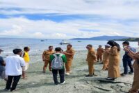 Kadis PUPR Touna Mohamad Asfan Supu menemui Lurah Bailo Baru Abidin ,S.Sos, bersama warga dusun Ue Nguri yang terdampak banjir rob di Pantai Kelurahan Bailo Baru Kecamatan Ampana Kota, Senin (8/12/2025).