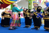 Bupati Touna Ilham Lawidu saat menerima Songkok To Bone dari Bupati Bone H. Asman Sulaeman pada HUT ke-22 Touna , Kamis (18/12/2025)