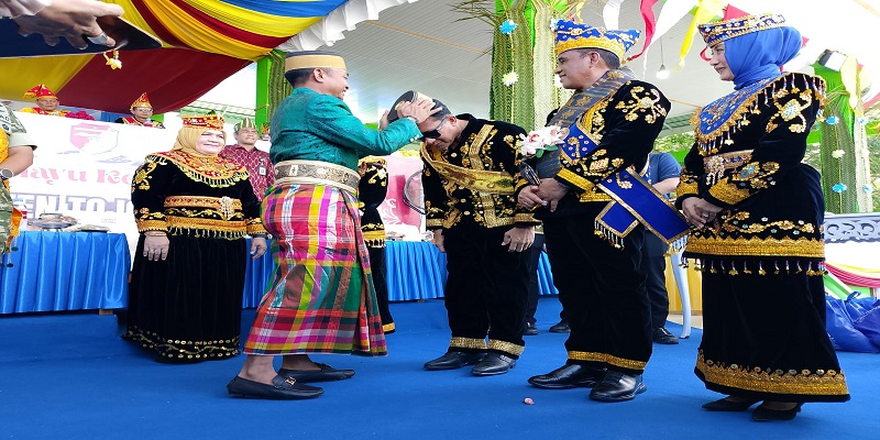 Bupati Touna Ilham Lawidu saat menerima Songkok To Bone dari Bupati Bone H. Asman Sulaeman pada HUT ke-22 Touna , Kamis (18/12/2025)