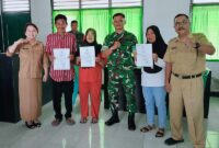 Warga masyarakat bersama Danramil 1307-05 Ratolindo, Kapten C.Ke, Risman dan Sekretaris Dukcapil Hasbullah DM saat foto bersama sambil menunjukan akte kelahiran yang telah selesai dibuat diruang kerja kantor Koramil setempat, Senin (9/2/2026)