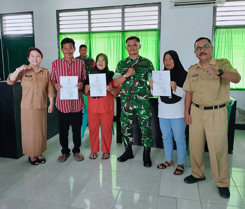 Warga masyarakat bersama Danramil 1307-05 Ratolindo, Kapten C.Ke, Risman dan Sekretaris Dukcapil Hasbullah DM saat foto bersama sambil menunjukan akte kelahiran yang telah selesai dibuat diruang kerja kantor Koramil setempat, Senin (9/2/2026)