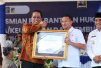 Bupati Tojo Una-Una, Ilham Lawidu (kiri), saat menerima piagam penghargaan dari Menteri Hukum RI usai penandatanganan kerja sama Posbakum Desa di Palu, Rabu (04/02/2026). (Foto: Dok. Pemkab Touna)