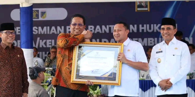 Bupati Tojo Una-Una, Ilham Lawidu (kiri), saat menerima piagam penghargaan dari Menteri Hukum RI usai penandatanganan kerja sama Posbakum Desa di Palu, Rabu (04/02/2026). (Foto: Dok. Pemkab Touna)