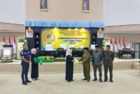 Ketua DPRD Tojo Una-Una, Gusnar A. Suleman, didampingi Wakil Ketua DPRD Rizal C. Panjili dan Jafar M. Amin menyerahkan dokumen LKPJ Tahun 2025 kepada Wakil Bupati Hj. Surya Lapasiri diruang sidang DPRD, Rabu (22/4/2026).