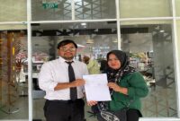 Siti Nurzahra Lijama didampingi kuasa hukumnya dari LBH-R, Firmansyah C. Rasyid, saat mengajukan surat pengaduan dugaan pelanggaran perlindungan konsumen terhadap WOM Finance ke Otoritas Jasa Keuangan di Palu, Selasa (19/5/2026).