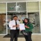 Siti Nurzahra Lijama didampingi kuasa hukumnya dari LBH-R, Firmansyah C. Rasyid, saat mengajukan surat pengaduan dugaan pelanggaran perlindungan konsumen terhadap WOM Finance ke Otoritas Jasa Keuangan di Palu, Selasa (19/5/2026).