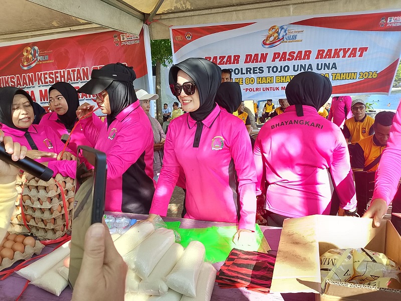 Ketua Bhayangkari Cabang Tojo Una-Una, Ny. Rosya Yanna, melayani langsung warga yang berbelanja pada pasar murah di Taman Jembatan Hayal (JH) Ampana, Minggu (21/6/2026).