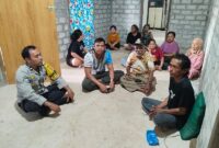 Kapolsek Ulubongka IPTU Muhanjir Wonti duduk mengenakan kaos bersama pemdes untuk memastikan kondisi Arsad Kulawi usai ditemukan selamat di Desa Bonevoto, Sabtu (6/6/2026).