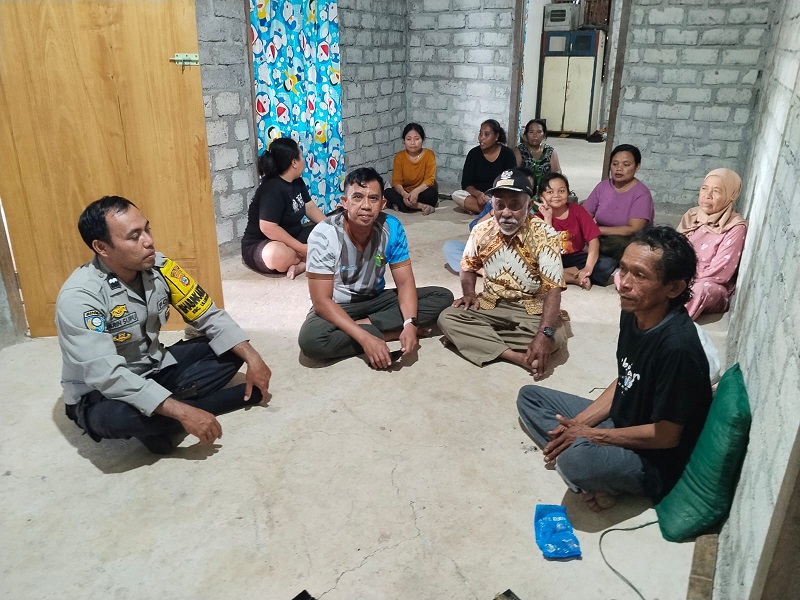 Kapolsek Ulubongka  IPTU Muhanjir Wonti duduk mengenakan kaos bersama pemdes untuk memastikan kondisi Arsad Kulawi usai ditemukan selamat   di Desa Bonevoto, Sabtu (6/6/2026).