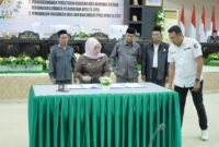 Ketua DPRD Gusnar A. Suleman bersama Wakil Bupati Hj. Surya Lapasiri menandatangani persetujuan bersama Ranperda Pertanggungjawaban APBD Tahun Anggaran 2025 dalam rapat paripurna DPRD Tojo Una-Una, Rabu (15/7/2026).