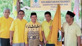 Ketua DPD II Partai Golkar Tojo Una-Una, Gusnar A. Suleman (kanan), menyerahkan  bendera pataka kepada Ketua PK Partai Golkar Ratolindo, Taslim, saat pengukuhan di Sekretariat Golkar Ratolindo, Senin (6/7/2026)