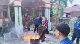 Kepala Dinas Pemadam Kebakaran dan Penyelamatan Kabupaten Tojo Una-Una, Alfred Leonard Lanu, menyaksikan simulasi penanganan kebakaran yang diperagakan personel Damkar dalam kegiatan sosialisasi pencegahan kebakaran di Kecamatan Tojo Barat, Selasa (7/7/2026).